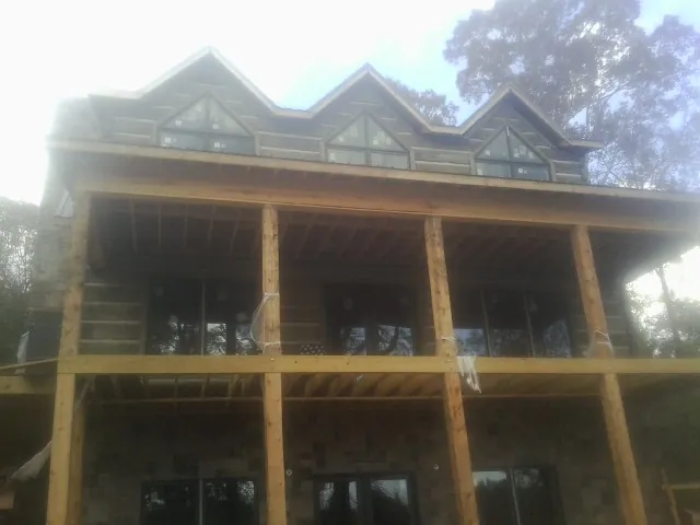 Dormers and porch framing on a large log home under construction — Roof Coating work by our crew in Fountain